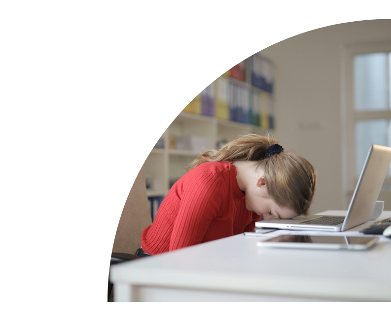 Woman sitting at desk with head laying on her laptop